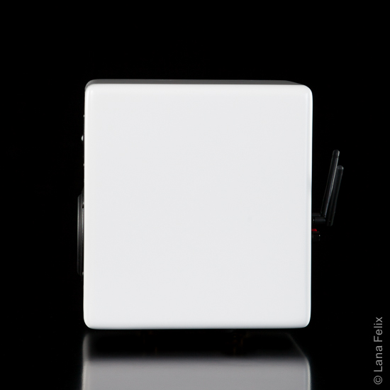 Side view of the small sized 2 way Powered Speaker with Bluetooth and WiFi wireless connectivity. Left powered speaker in white.